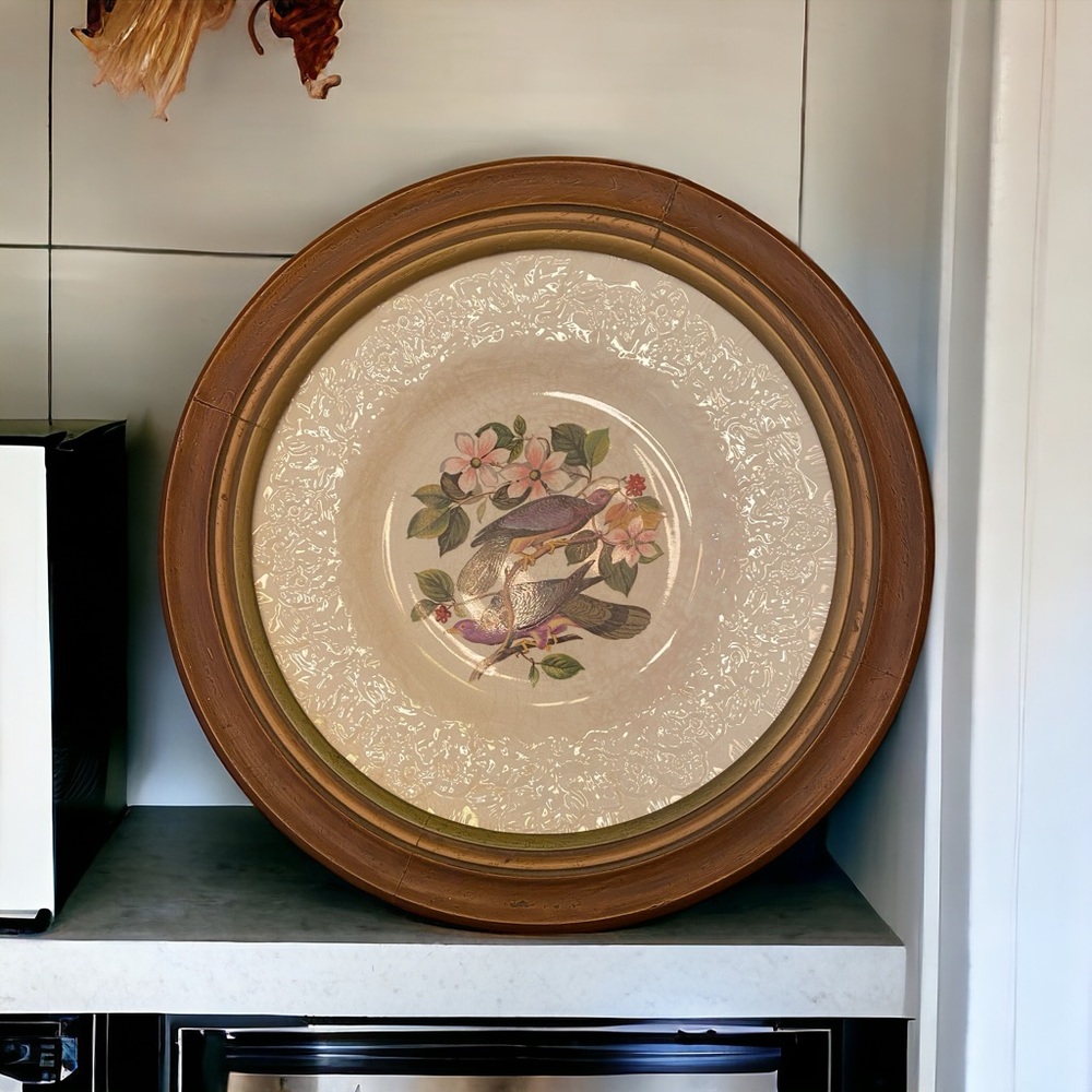 Vintage dinner plate mounted in a wooden frame for wall hanging.